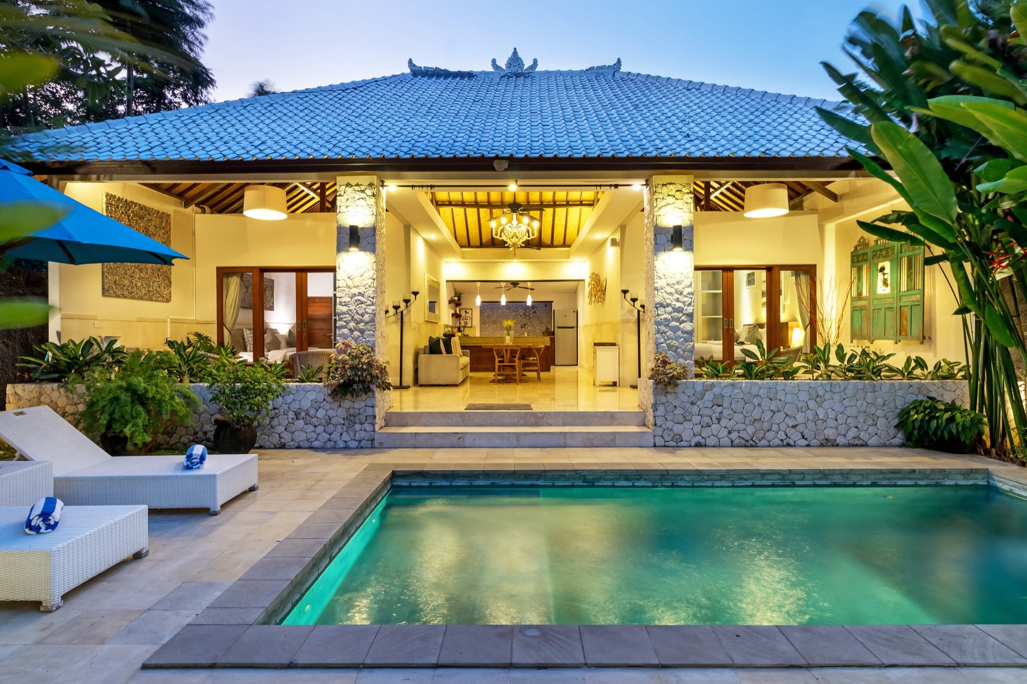 Villa Blue Bali — private pool lit at dusk with the open-plan living pavilion glowing behind